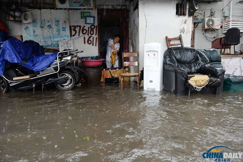 10月8日，上海市杨树浦路，一位市民家门口被积水淹没。赖鑫琳摄（来源：国际在线）