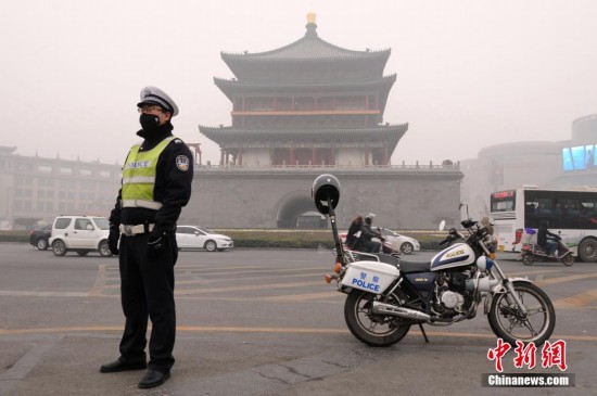 12月24日，一位交警戴着口罩于西安钟楼前执勤。