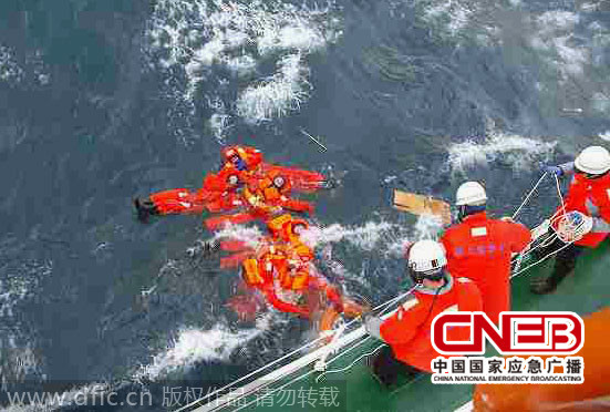 当地时间2014年12月26日，日本第2管区海上保安总部提供图片，在青森县海域沉没的柬埔寨货船上的船员被救起。   