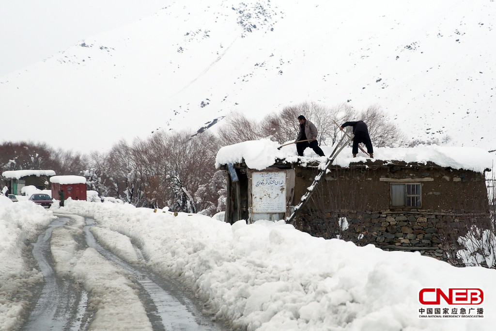 雪崩現(xiàn)場附近村莊里的男子清理屋頂?shù)姆e雪