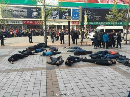 王府井步行街10余名不明身份人员躺在地上