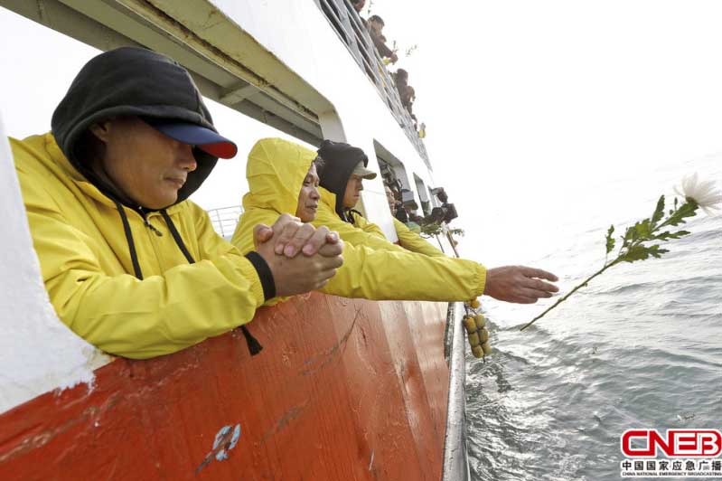 当地时间2015年4月15日，韩国珍岛，“世越号”沉船事故一周年前夕，遇难者家属向事发海域投掷鲜花。