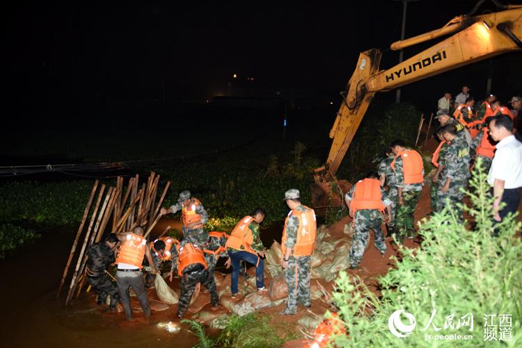 江西进贤一涵管闸板发生漏水，5个村庄千名群众疏散。图为该县防总组织人员抢修。
