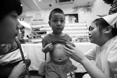 昨天，在北京中医医院儿科，医生正在为孩子们贴敷“三伏贴”。当天，本市正式入伏，也是“三伏贴”正式开贴的日子。本报记者 方非摄