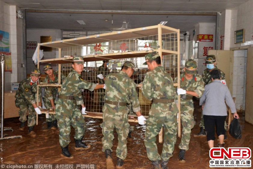 7月24日，在福建省龙岩市连城县医院住院部一楼，武警官兵在清理被洪水浸泡的柜子。