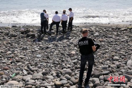 當?shù)貢r間8月2日，法屬留尼旺首府圣但尼附近的一處海灘上，警員正在現(xiàn)場對金屬殘片進行勘察。