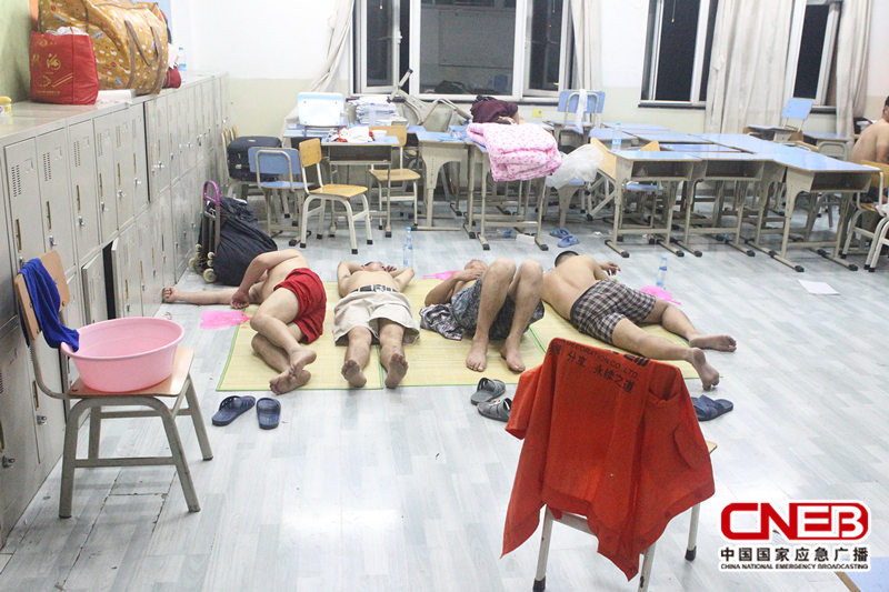 天津滨海新区开发区第二小学安置点内，受灾群众席地而睡。