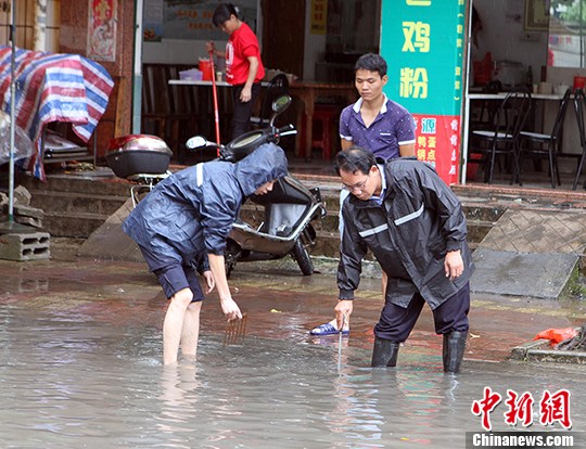 工作人员紧急疏通下水道。　凌福龙　摄