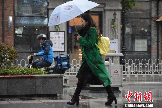 武汉细雨纷飞，市民冒雨出行。　马芙蓉　摄