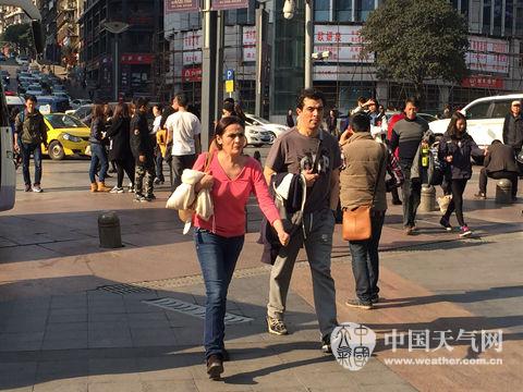 27日，重庆阳光明媚，最高气温达20℃，行人穿短袖逛街。(摄影：吴琦)