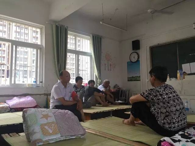 在安徽郎溪县建平镇中学安置点，受灾群众围着墙上的“大喇叭”，收听最新的防疫抗灾信息。记者郭翔宇摄。