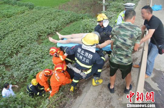 从车内飞出坠落在路边田地的女子被救起送医。 詹枭 摄