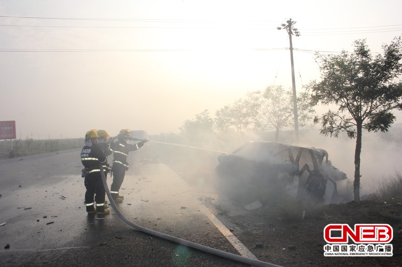 面包车起火，车身已基本被烧成空架，消防官兵正在对其进行灭火。