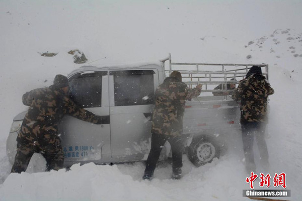 12日，新疆阿勒泰边防官兵在救援被困车辆。（图片来源：中新网）