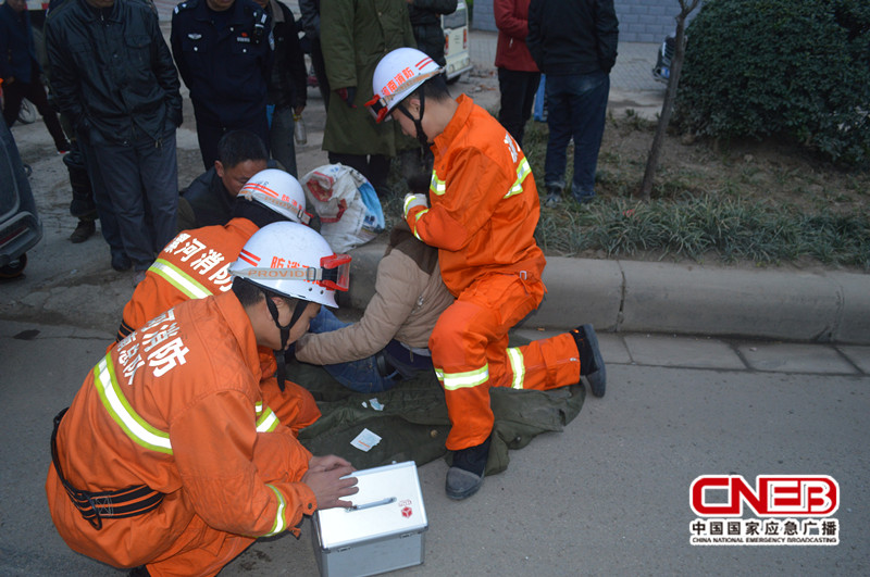 救援人员一直单膝跪地支撑着，并用抢险救援车内的急救箱对车主外伤进行简单处理。