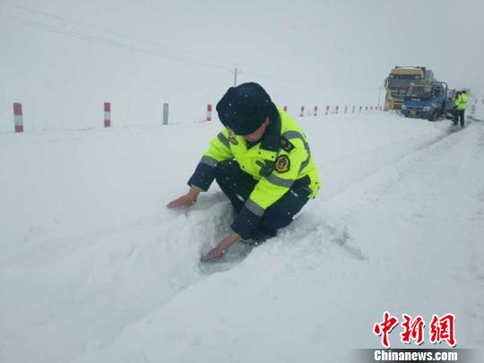 图为路政人员测量积雪深度超过20公分　裴生敏 摄