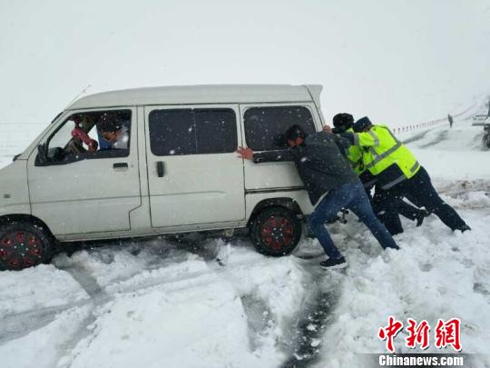 图为路政执法人员推搡被困雪中的车辆 裴生敏 摄