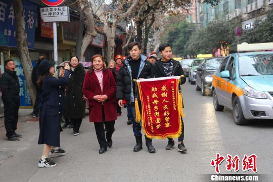杨某某夫妇携失而复得的儿子向警方赠送锦旗。