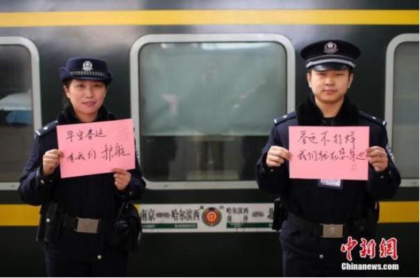 南京火车站站台上的值班民警送出温馨祝福语。中新社记者 泱波 摄