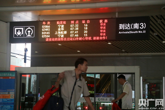 8月10日，一位乘客从杭州东站停运的电子指示牌前走过。（央广网记者 魏炜 摄）