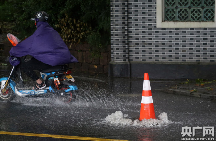 8月10日，一位市民在杭州西湖北山路艰难骑行。（央广网记者 魏炜 摄）