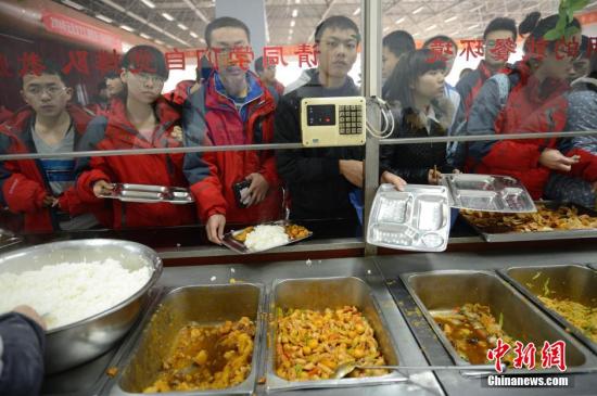 资料图：学生在食堂打饭。中新社发 刘文华 摄