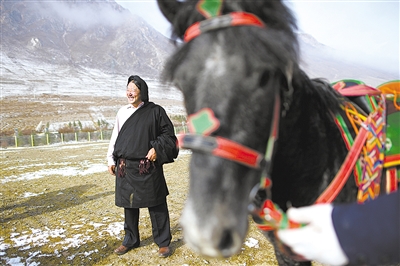 在青海省玉树藏族自治州加吉娘社区民族服饰加工车间，当地牧民索南看卓在缝制布饰（四月三日摄）。 新华社记者 张龙 摄